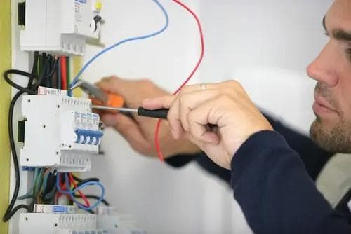 Électricien intervenant sur un tableau électrique